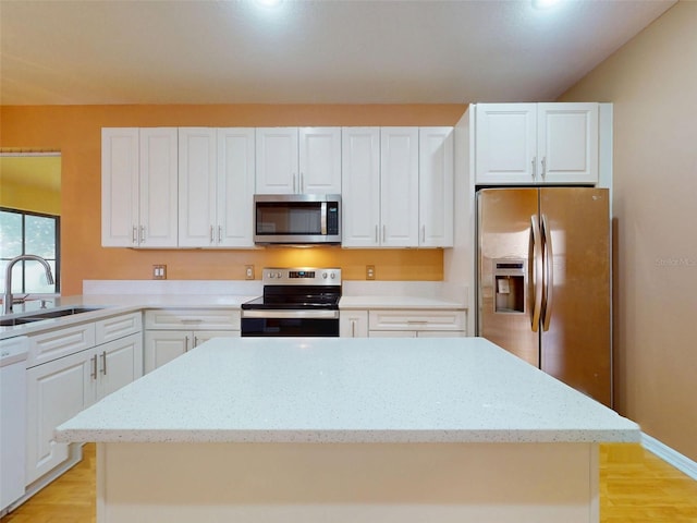 7985 Saint Giles Pl, Orlando, FL 32835 - kitchen with appliances with stainless steel finishes, light wood-type flooring, white cabinetry, and recessed lighting
