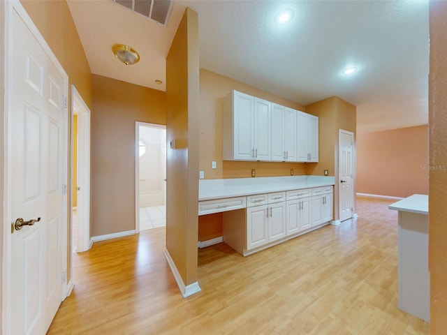 7985 Saint Giles Pl, Orlando, FL 32835 - kitchen with light countertops, light wood-type flooring, white cabinets, and recessed lighting