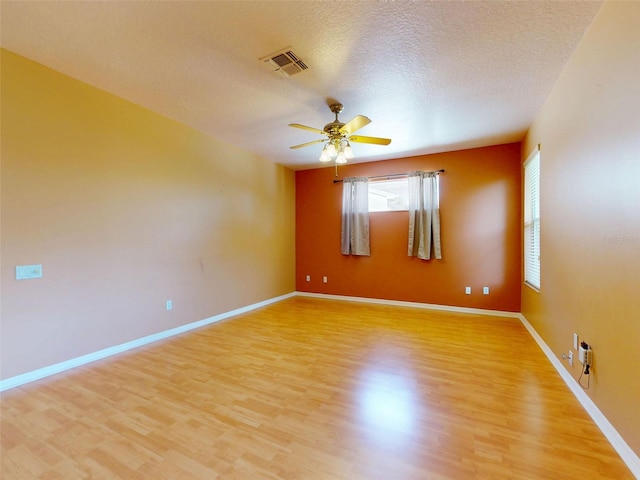 7985 Saint Giles Pl, Orlando, FL 32835 - unfurnished room with plenty of natural light, light wood-style floors, ceiling fan, and a textured ceiling