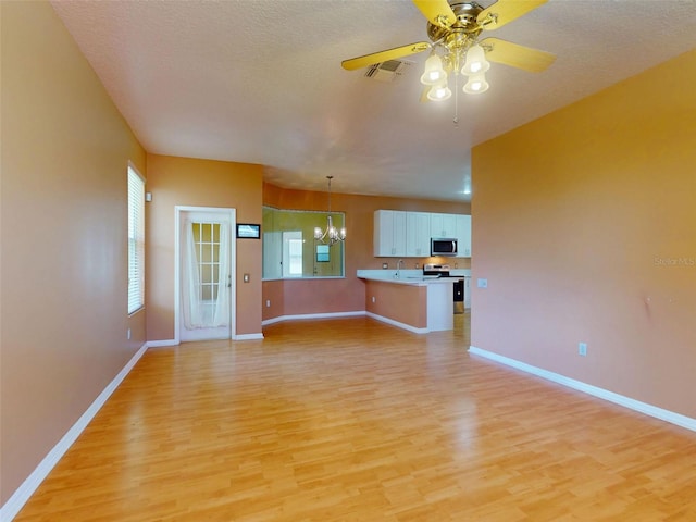 7985 Saint Giles Pl, Orlando, FL 32835 - unfurnished living room with light wood-style floors, a chandelier, healthy amount of natural light, and a textured ceiling