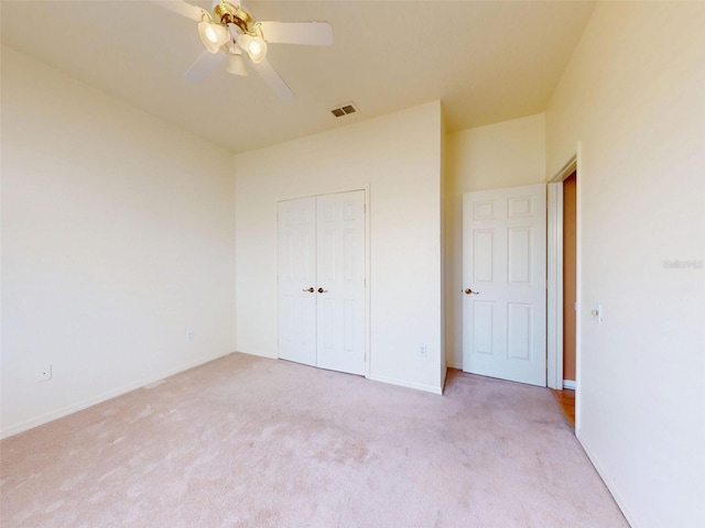 7985 Saint Giles Pl, Orlando, FL 32835 - unfurnished bedroom with light colored carpet, a closet, and a ceiling fan