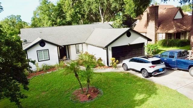 957 Southridge Trl, Altamonte Springs, FL 32714 - single story home featuring concrete driveway, a front lawn, an attached garage, and a chimney