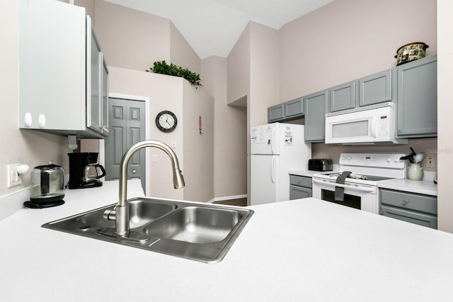 1520 Gulf Vue Dr, Haines City, FL 33844 - kitchen featuring white appliances, light countertops, gray cabinetry, and vaulted ceiling