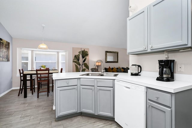 1520 Gulf Vue Dr, Haines City, FL 33844 - kitchen with dishwasher, a peninsula, gray cabinets, light countertops, and light wood-style floors