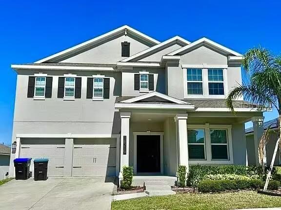 18219 Oliver Twist Way, Winter Garden, FL 34787 - view of front of home with a garage, concrete driveway, and stucco siding