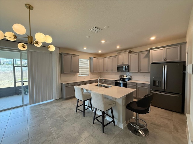 18219 Oliver Twist Way, Winter Garden, FL 34787 - kitchen featuring appliances with stainless steel finishes, gray cabinets, a breakfast bar area, light countertops, and pendant lighting