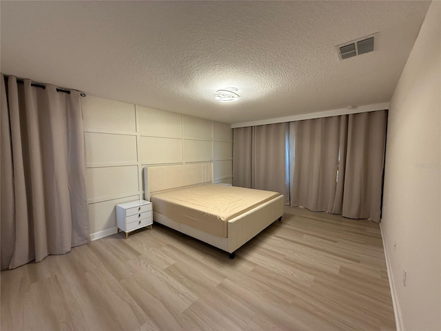 18219 Oliver Twist Way, Winter Garden, FL 34787 - bedroom featuring light wood-type flooring and a textured ceiling