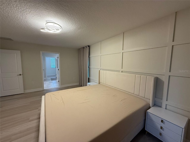 18219 Oliver Twist Way, Winter Garden, FL 34787 - unfurnished bedroom with wood finished floors, a textured ceiling, and ensuite bath