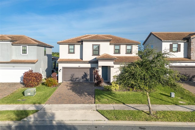 207 Macaulays Cv, Haines City, FL 33844 - view of front of house featuring a garage, stucco siding, decorative driveway, and a front yard