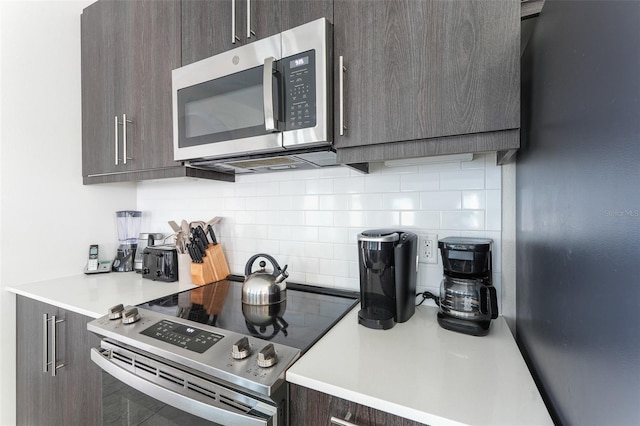 207 Macaulays Cv, Haines City, FL 33844 - kitchen featuring appliances with stainless steel finishes, decorative backsplash, dark brown cabinets, light countertops, and modern cabinets