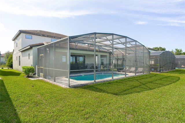 207 Macaulays Cv, Haines City, FL 33844 - back of property featuring a lawn, stucco siding, and glass enclosure