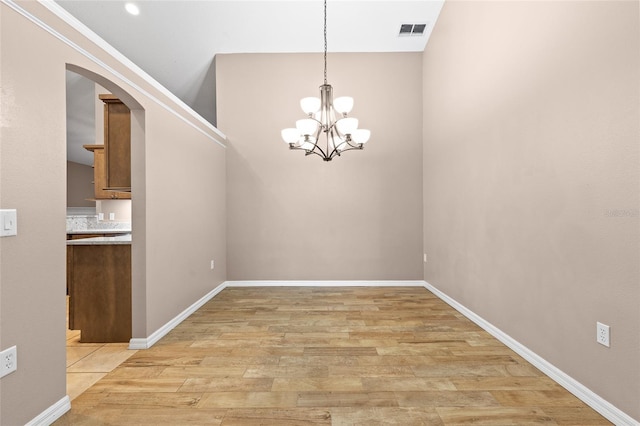 3245 Kings Ridge Ter, Deltona, FL 32725 - unfurnished dining area with arched walkways, a chandelier, and light wood-type flooring