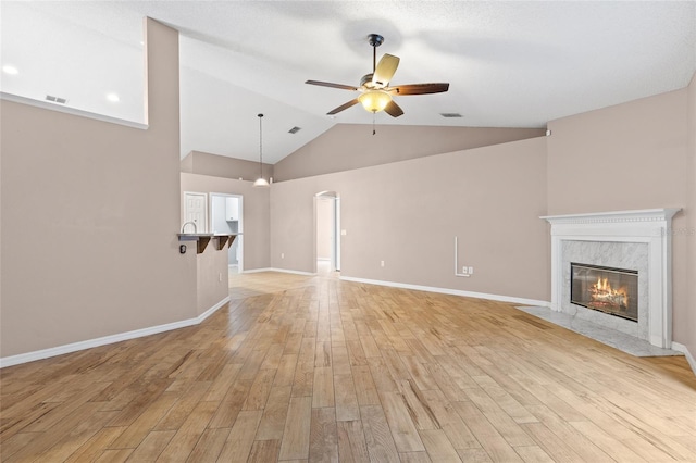 3245 Kings Ridge Ter, Deltona, FL 32725 - unfurnished living room featuring a ceiling fan, light wood-style flooring, a premium fireplace, and high vaulted ceiling