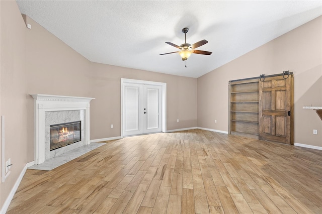 3245 Kings Ridge Ter, Deltona, FL 32725 - unfurnished living room with ceiling fan, vaulted ceiling, light wood-style floors, and a high end fireplace