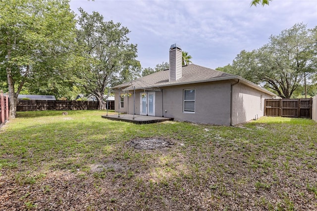 3245 Kings Ridge Ter, Deltona, FL 32725 - back of property featuring stucco siding, a chimney, a fenced backyard, and a deck