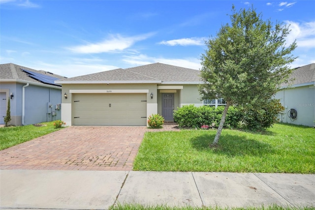 9370 Westmorely St, Groveland, FL 34736 - ranch-style home with an attached garage, decorative driveway, stucco siding, a shingled roof, and a front lawn