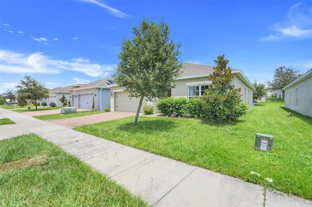 9370 Westmorely St, Groveland, FL 34736 - view of front of home featuring a front lawn, an attached garage, driveway, and stucco siding