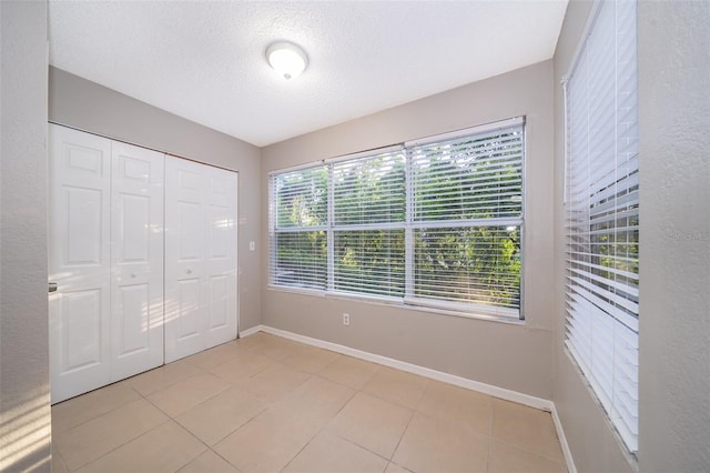 5140 Conroy Rd Unit 16, Orlando, FL 32811 - unfurnished bedroom with light tile patterned floors, a textured ceiling, and a closet