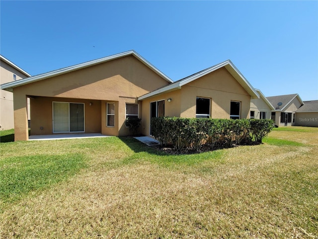 1914 Commander Way, Kissimmee, FL 34746 - back of house featuring stucco siding, a yard, and a patio area