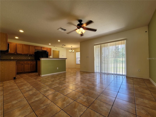 1914 Commander Way, Kissimmee, FL 34746 - kitchen with ceiling fan, freestanding refrigerator, a chandelier, dark countertops, and decorative backsplash