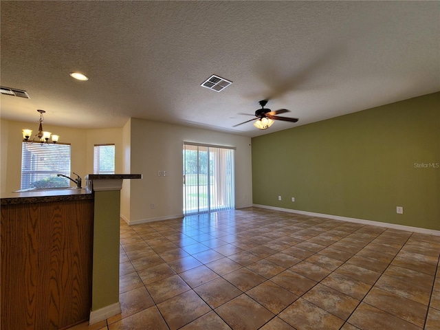 1914 Commander Way, Kissimmee, FL 34746 - unfurnished living room featuring a chandelier, ceiling fan, tile patterned floors, a textured ceiling, and recessed lighting