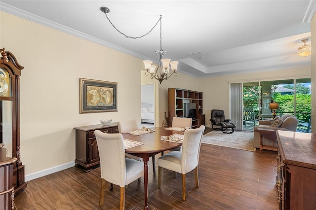 3685 Corsica Ln, Clermont, FL 34711 - dining room with dark wood finished floors, a chandelier, ornamental molding, and a raised ceiling