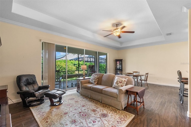 3685 Corsica Ln, Clermont, FL 34711 - living area featuring a tray ceiling, dark wood finished floors, a ceiling fan, and ornamental molding