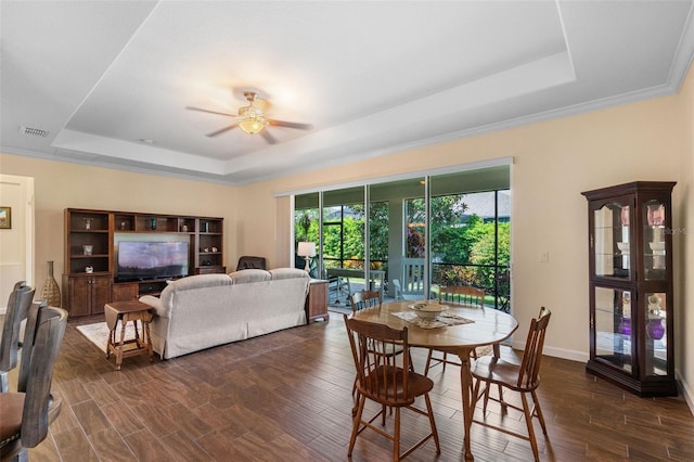 3685 Corsica Ln, Clermont, FL 34711 - dining area featuring a tray ceiling, dark wood-style floors, a ceiling fan, and ornamental molding