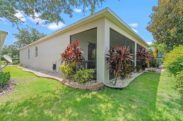 3685 Corsica Ln, Clermont, FL 34711 - view of side of home featuring stucco siding, a lawn, and a sunroom