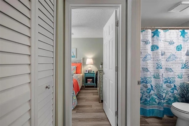431 Cerromar Ln Unit 446, Venice, FL 34293 - full bath featuring wood finished floors, a textured ceiling, connected bathroom, and curtained shower