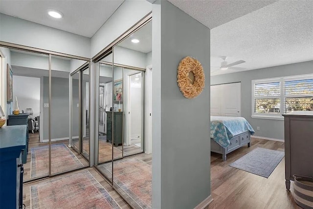 431 Cerromar Ln Unit 446, Venice, FL 34293 - bedroom with multiple closets, wood finished floors, a textured ceiling, and a ceiling fan