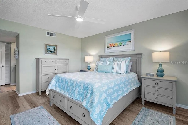 431 Cerromar Ln Unit 446, Venice, FL 34293 - bedroom with wood finished floors, a textured ceiling, and ceiling fan