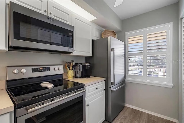 431 Cerromar Ln Unit 446, Venice, FL 34293 - kitchen with appliances with stainless steel finishes, white cabinets, wood finished floors, and light countertops