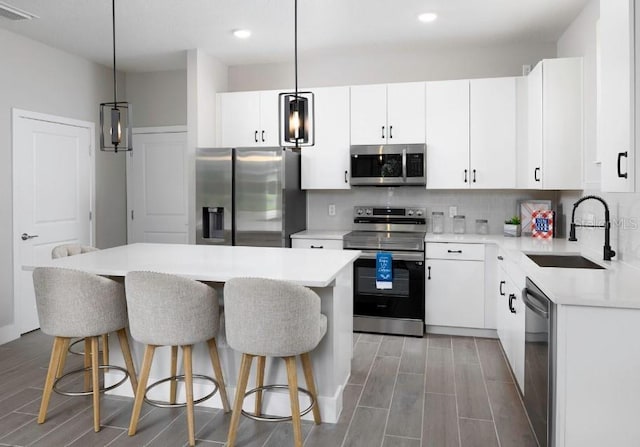 2105 Broome St, Kissimmee, FL 34743 - kitchen featuring appliances with stainless steel finishes, a kitchen breakfast bar, recessed lighting, tasteful backsplash, and light countertops