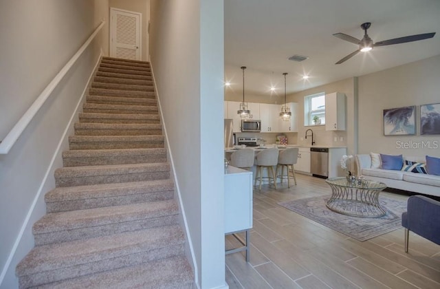 2113 Broome St, Kissimmee, FL 34743 - staircase featuring wood finished floors and a ceiling fan