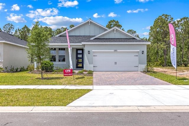1261 Champions Dr, Daytona Beach, FL 32124 - single story home featuring driveway, a front yard, board and batten siding, an attached garage, and roof with shingles