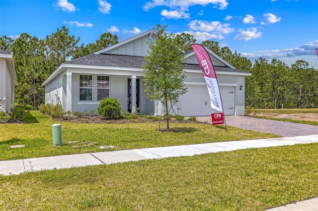 1261 Champions Dr, Daytona Beach, FL 32124 - ranch-style home with an attached garage, driveway, a front lawn, and a shingled roof