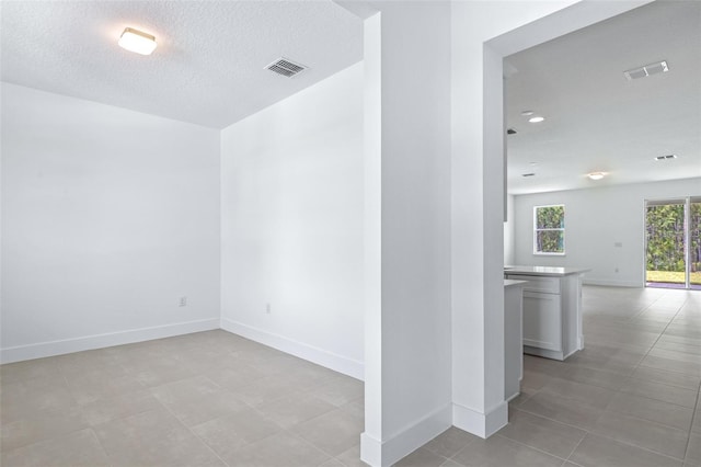 1261 Champions Dr, Daytona Beach, FL 32124 - unfurnished room with a textured ceiling and light tile patterned flooring
