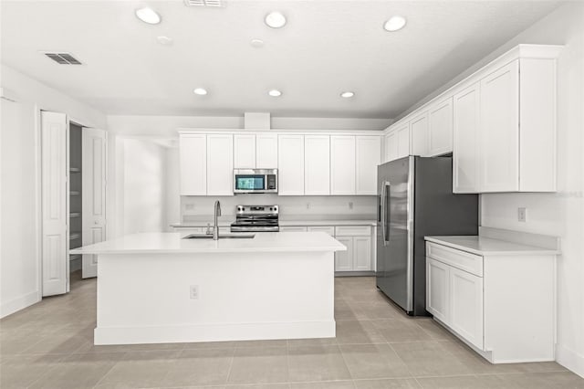 1261 Champions Dr, Daytona Beach, FL 32124 - kitchen featuring stainless steel appliances, white cabinets, a kitchen island with sink, and recessed lighting