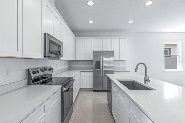 1261 Champions Dr, Daytona Beach, FL 32124 - kitchen with appliances with stainless steel finishes, recessed lighting, light countertops, white cabinetry, and a textured ceiling