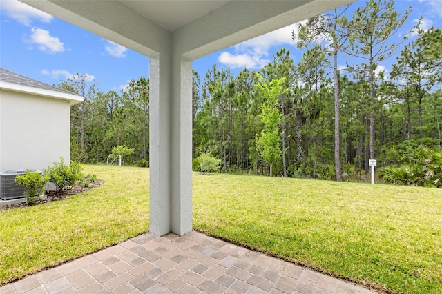 1261 Champions Dr, Daytona Beach, FL 32124 - view of grassy yard featuring a patio area and a forest view