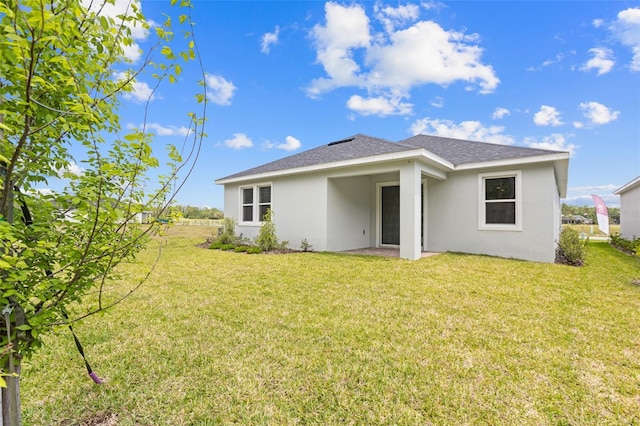 1261 Champions Dr, Daytona Beach, FL 32124 - back of property with stucco siding, a yard, and roof with shingles