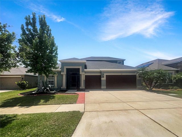 12671 Flatwood Creek Dr, Gibsonton, FL 33534 - prairie-style house with a garage, concrete driveway, a front lawn, and stucco siding