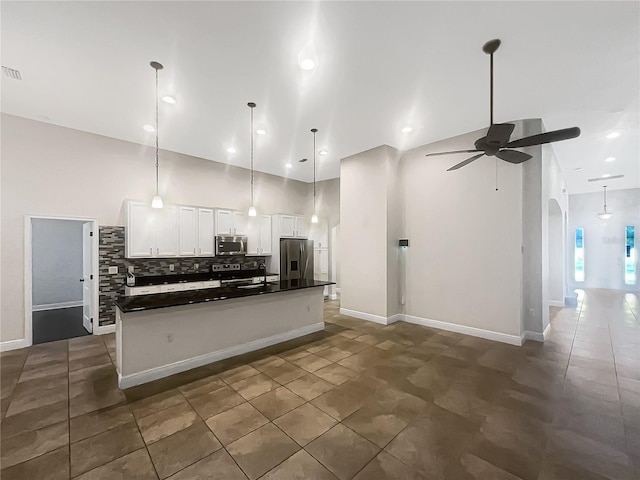 12671 Flatwood Creek Dr, Gibsonton, FL 33534 - kitchen with stainless steel appliances, a ceiling fan, dark countertops, backsplash, and white cabinets