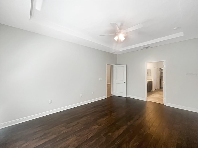 12671 Flatwood Creek Dr, Gibsonton, FL 33534 - unfurnished bedroom with a raised ceiling, dark wood-style floors, ceiling fan, and connected bathroom