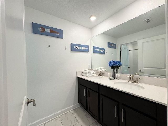 4192 Paragraph Dr, Kissimmee, FL 34746 - bathroom with double vanity, marble finish floors, a textured ceiling, and a shower