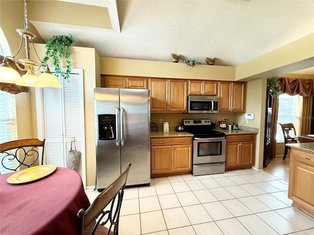 9803 Terrace Trail Ln, Temple Terrace, FL 33637 - kitchen with stainless steel appliances, a textured ceiling, light tile patterned floors, brown cabinets, and light stone countertops