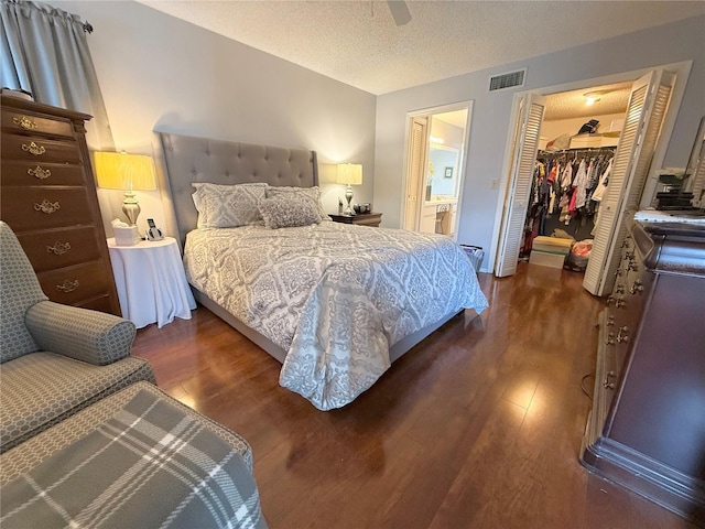 9803 Terrace Trail Ln, Temple Terrace, FL 33637 - bedroom featuring dark wood-style floors, a spacious closet, ensuite bath, and a textured ceiling