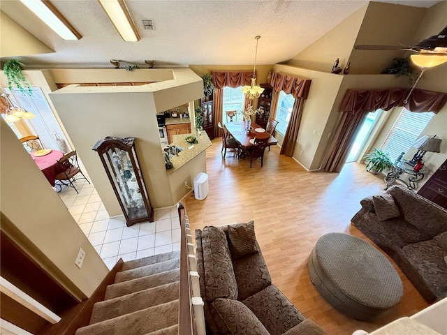 9803 Terrace Trail Ln, Temple Terrace, FL 33637 - living area featuring a chandelier, a textured ceiling, light wood-type flooring, and vaulted ceiling