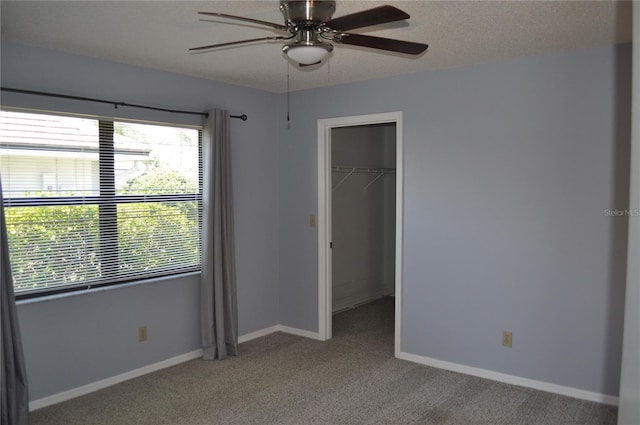 721 Elkhorn Rd, Sun City Center, FL 33573 - unfurnished bedroom with multiple windows, a walk in closet, carpet floors, and a ceiling fan